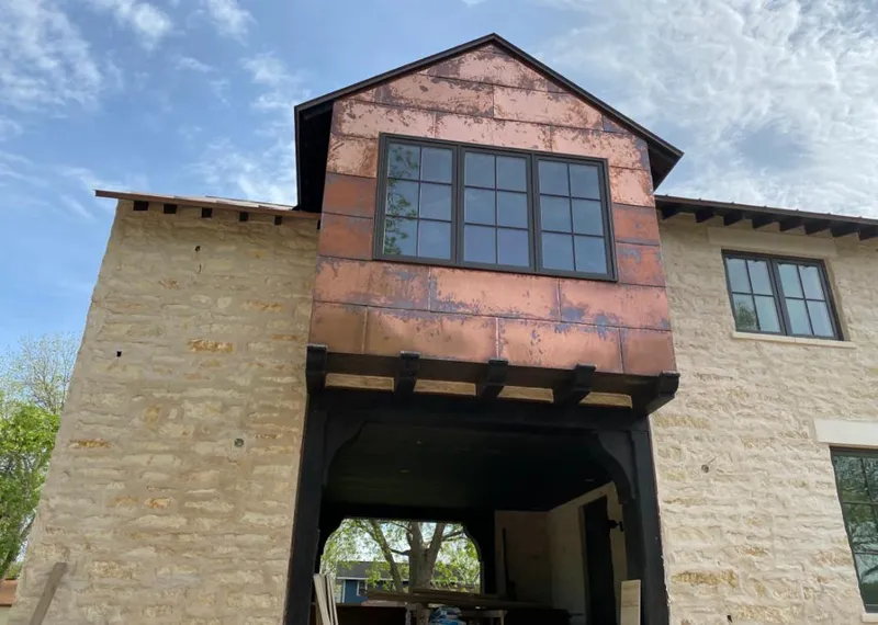 Copper metal panel facade on a stone building for Roof Repair in Kennett